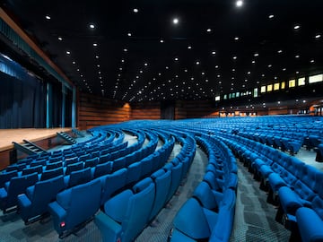a large auditorium with blue chairs