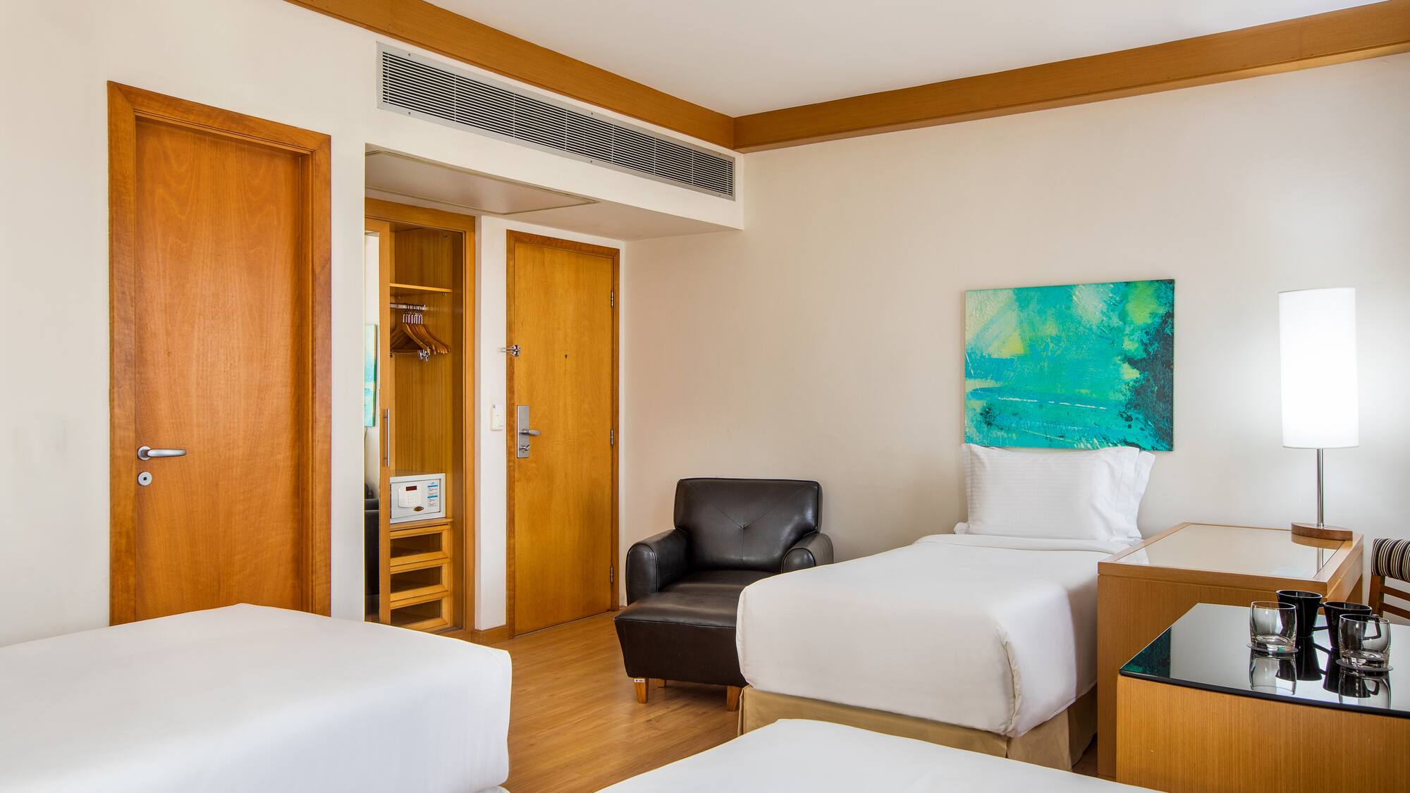 a room with two beds and a chair