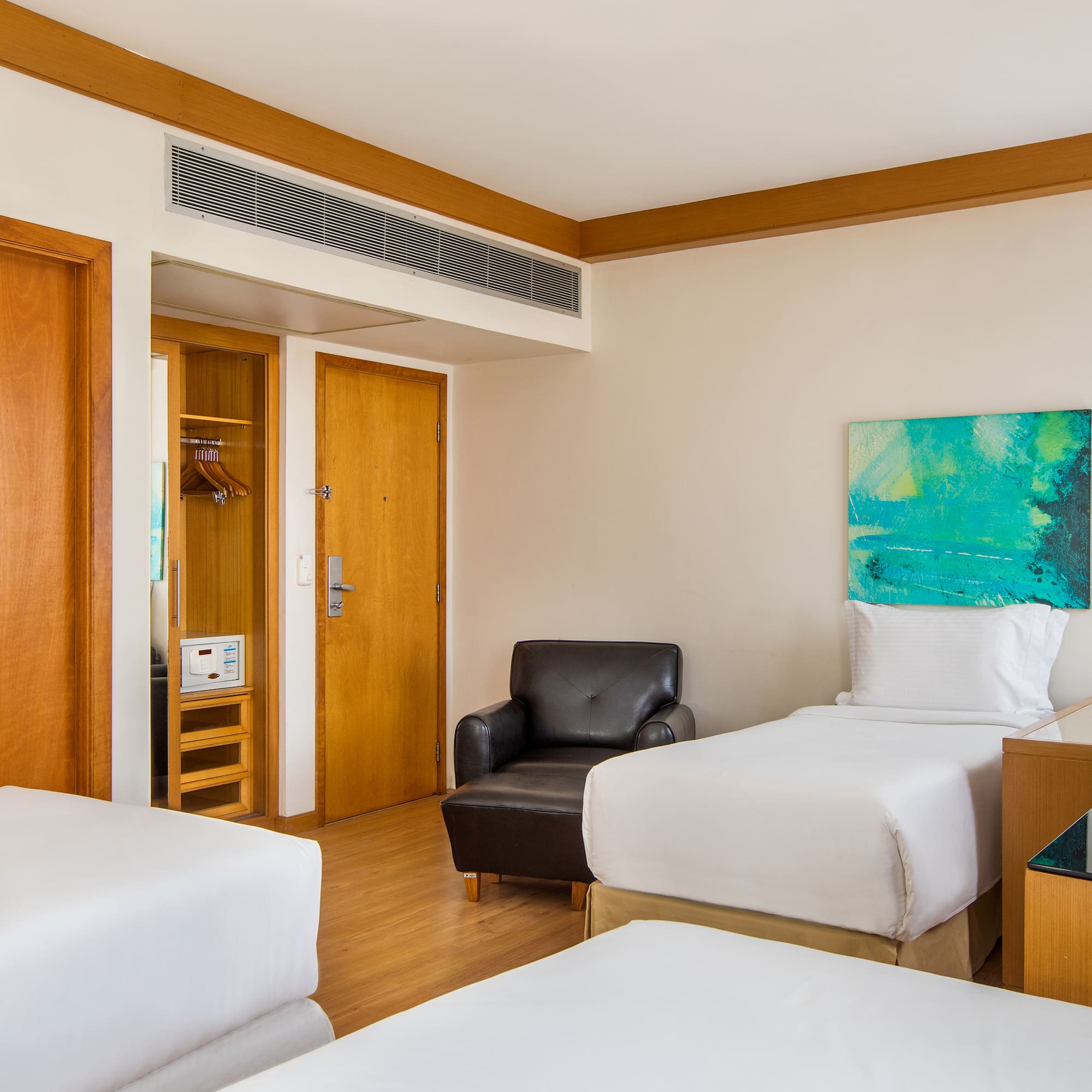 a room with two beds and a chair