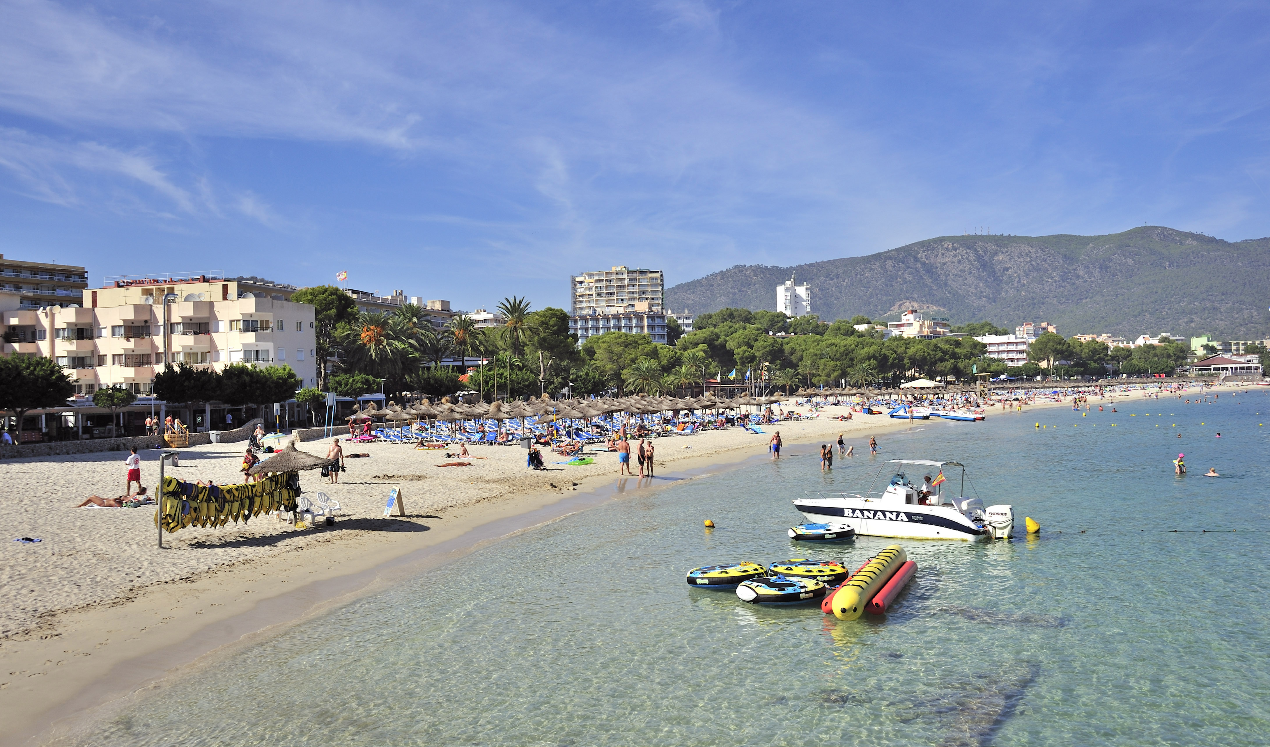 a beach with boats and people on it