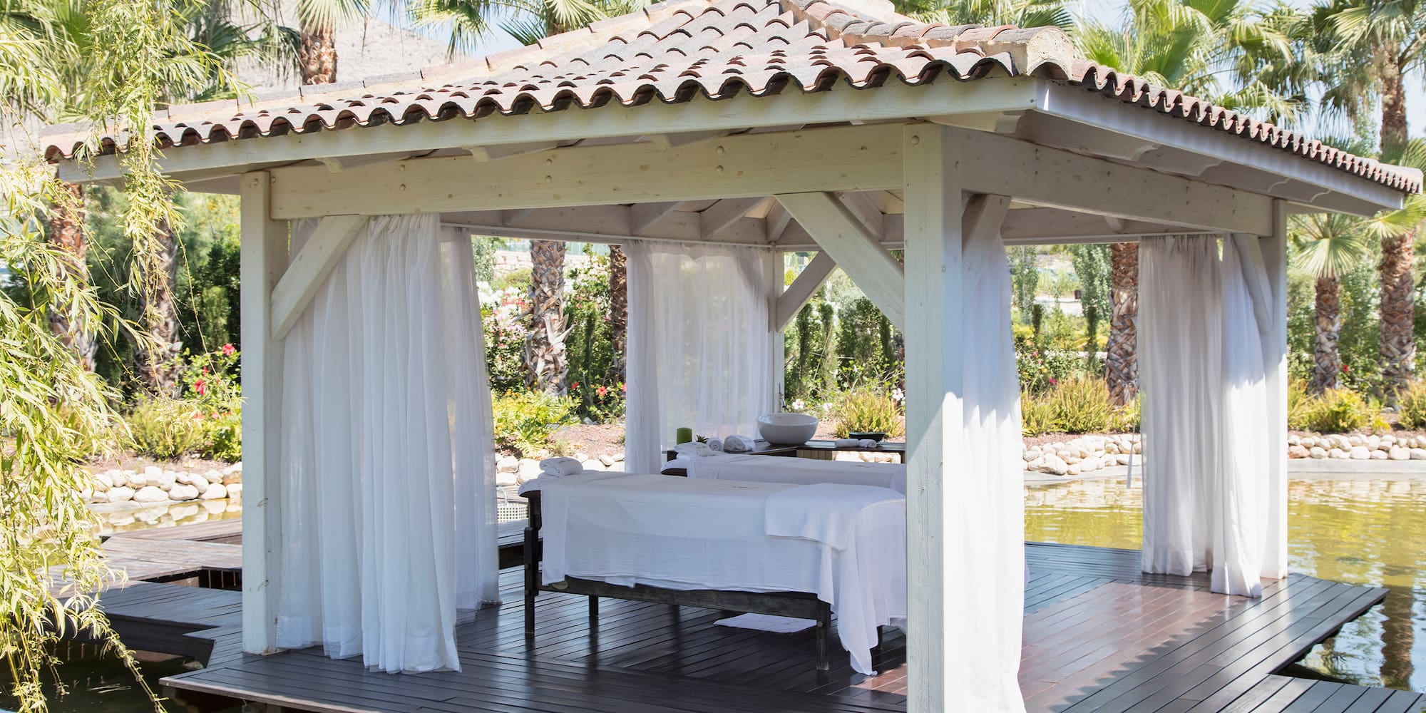 a white gazebo with white curtains on it