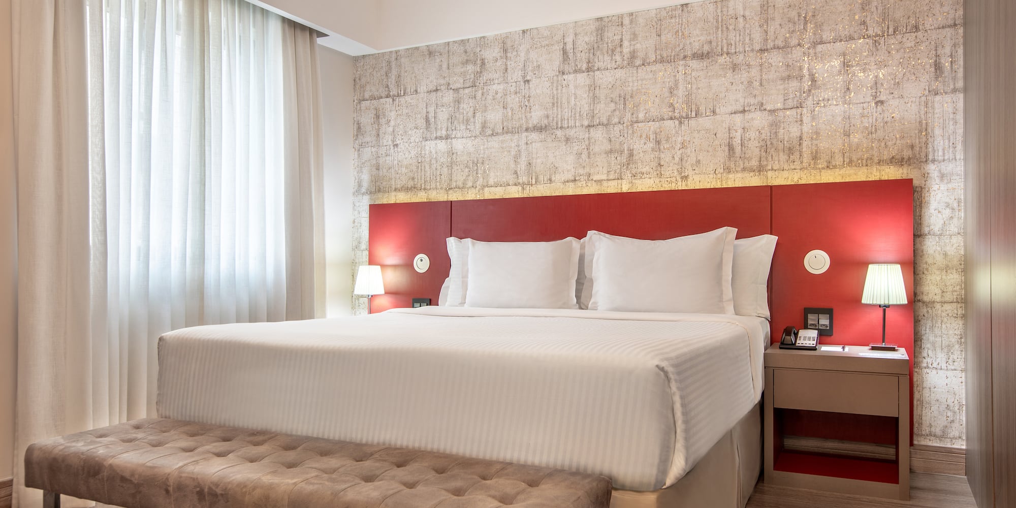 a bed with a bench and a lamp