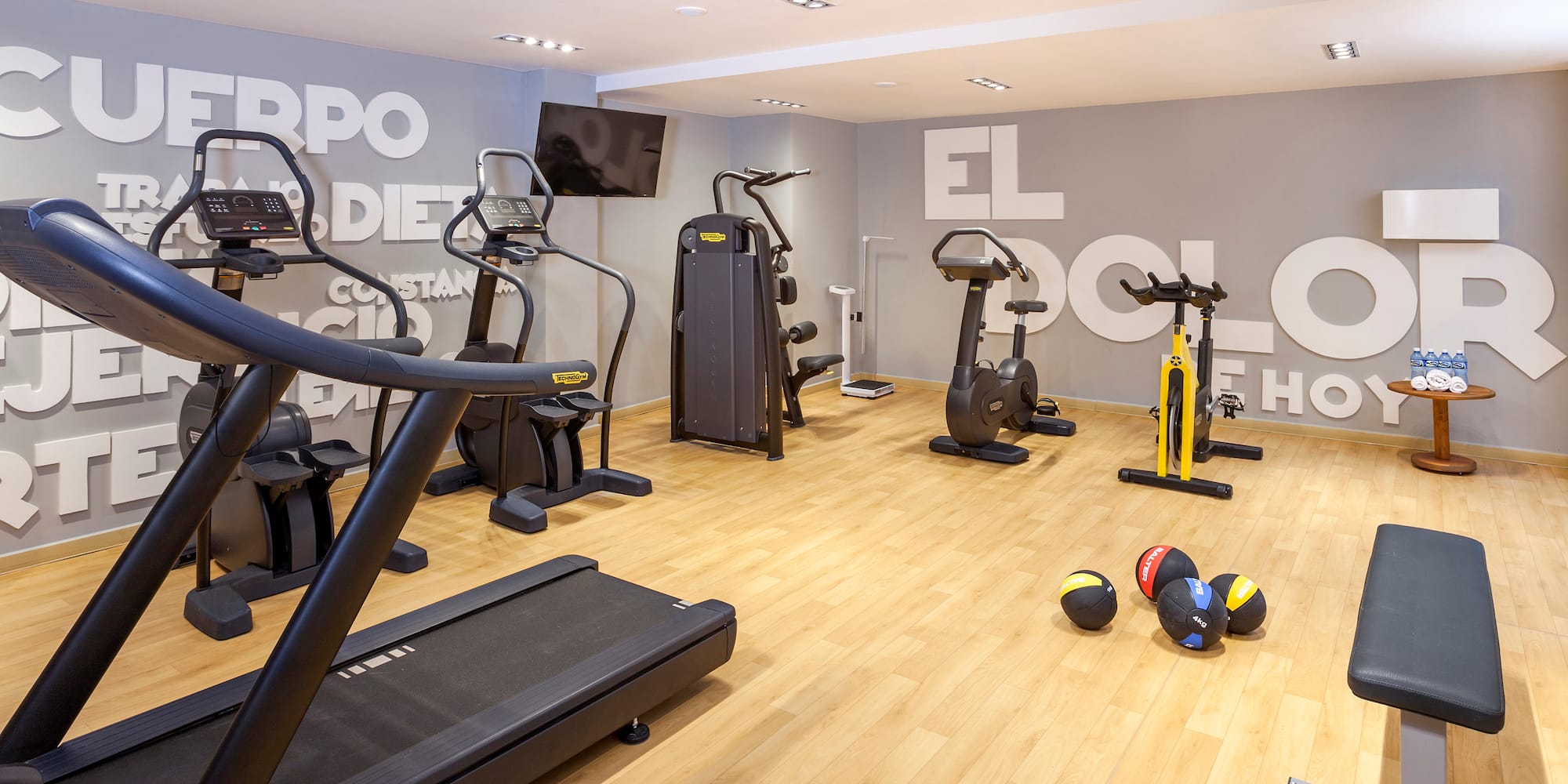 a room with exercise equipment and a wall with white letters