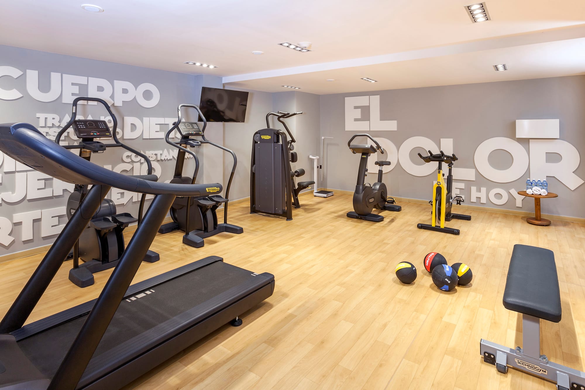 a room with exercise equipment and a wall with white letters