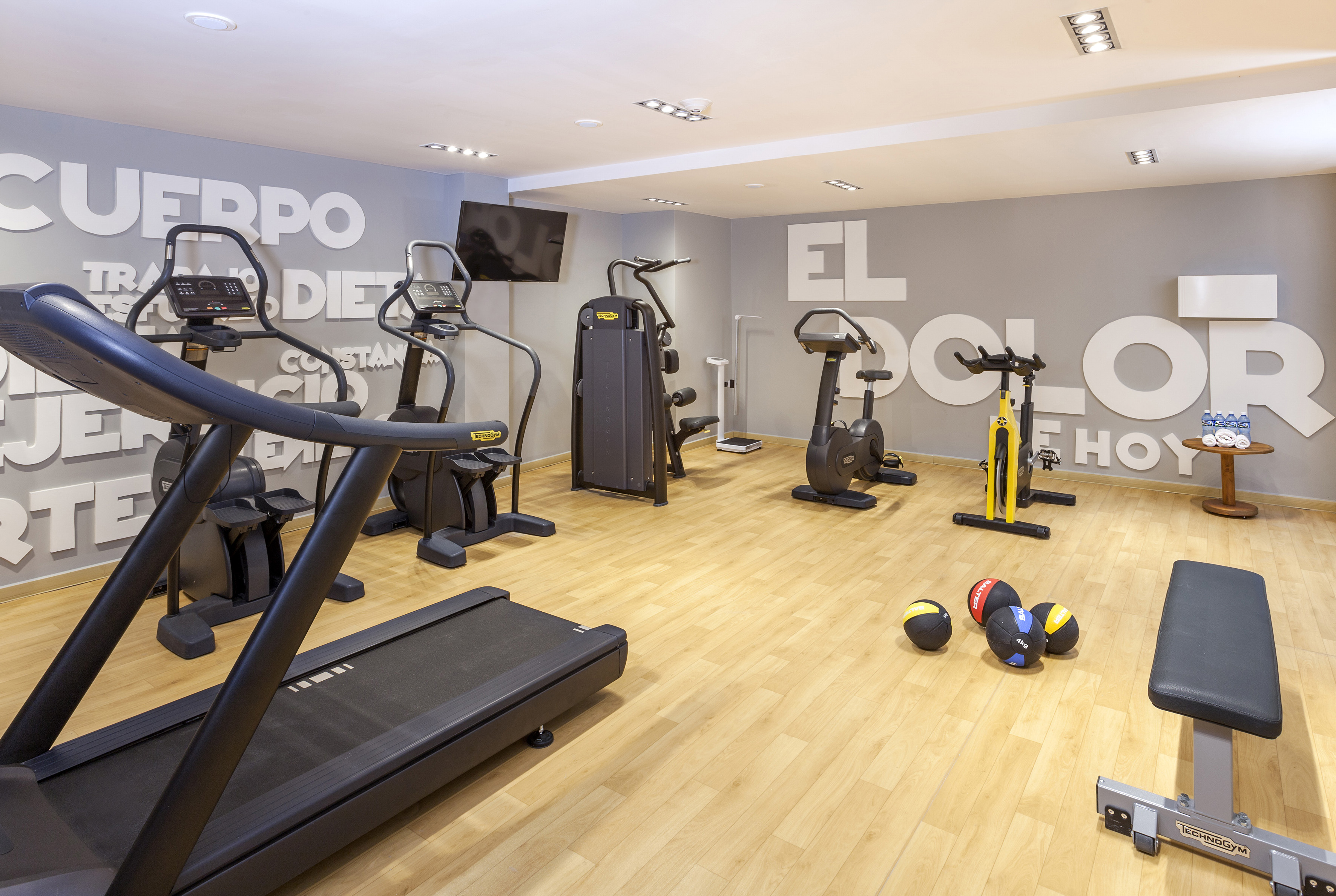 a room with exercise equipment and a wall with white letters