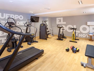 a room with exercise equipment and a wall with white letters