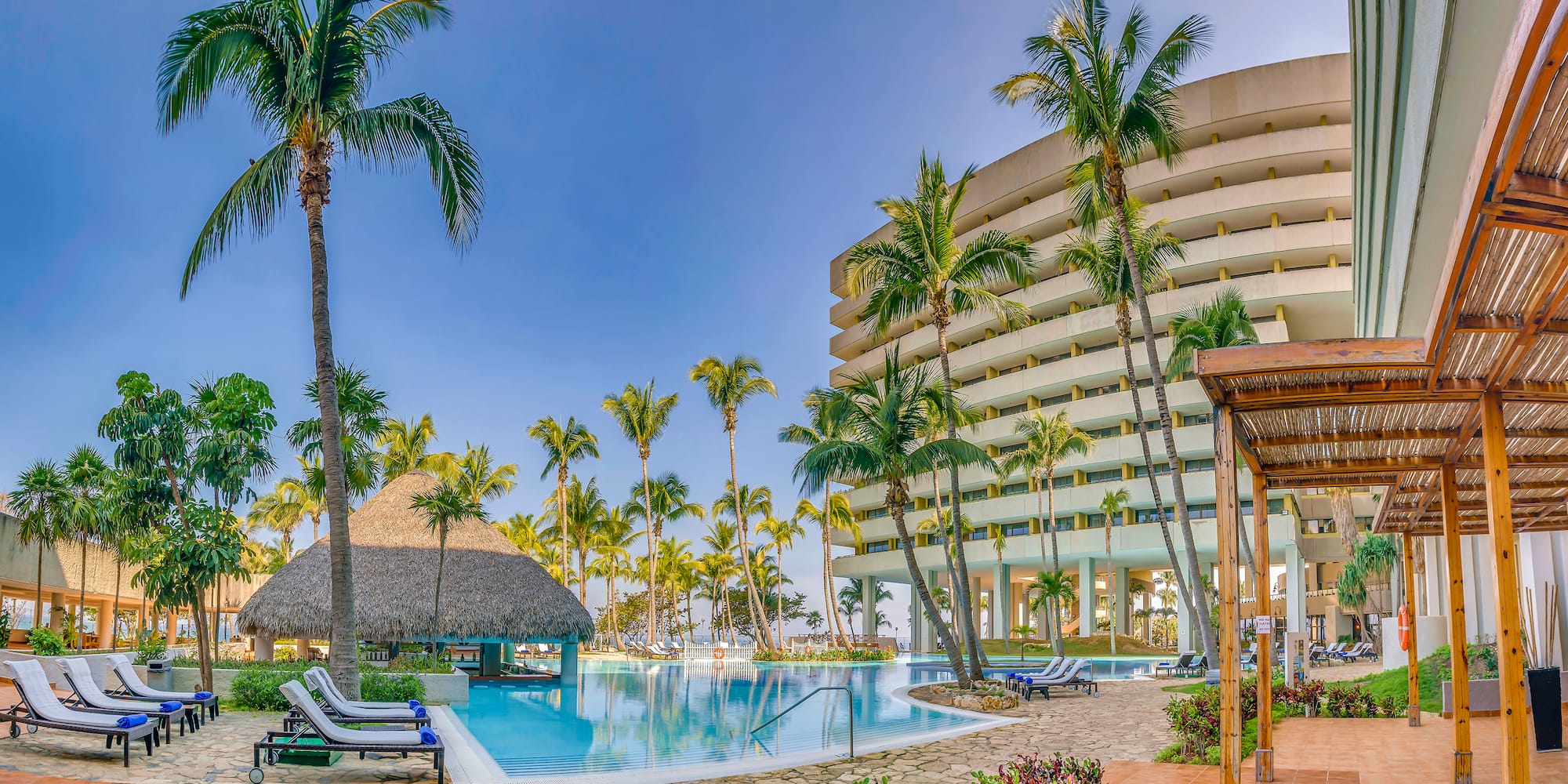 a pool with palm trees and a building