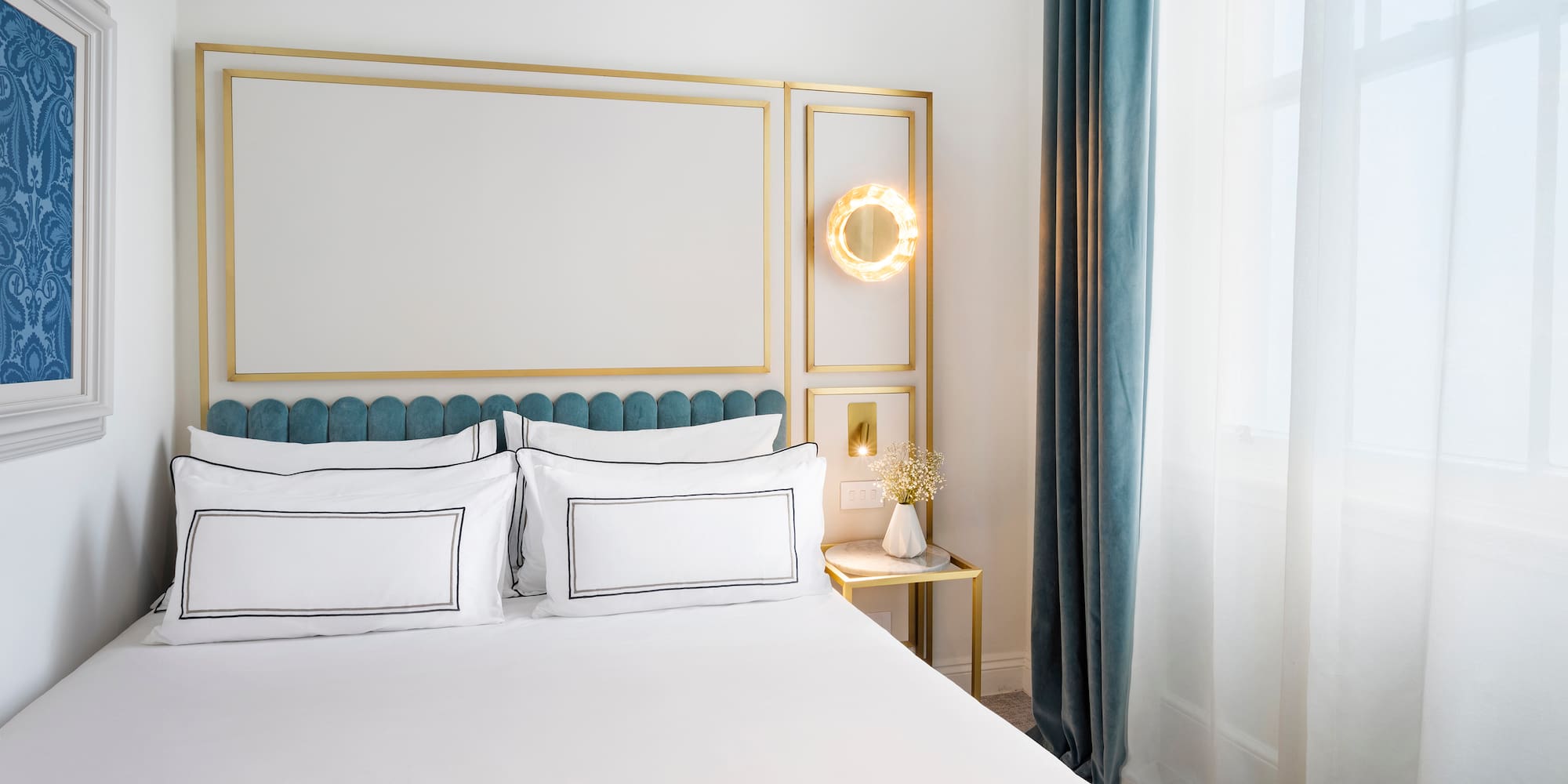 a bed with white sheets and a gold frame