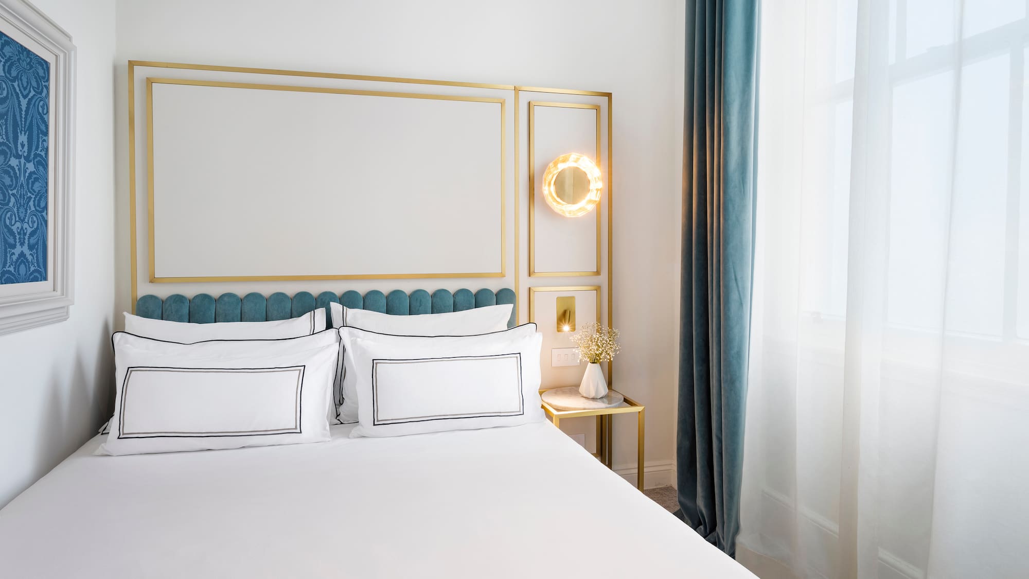 a bed with white sheets and a gold frame