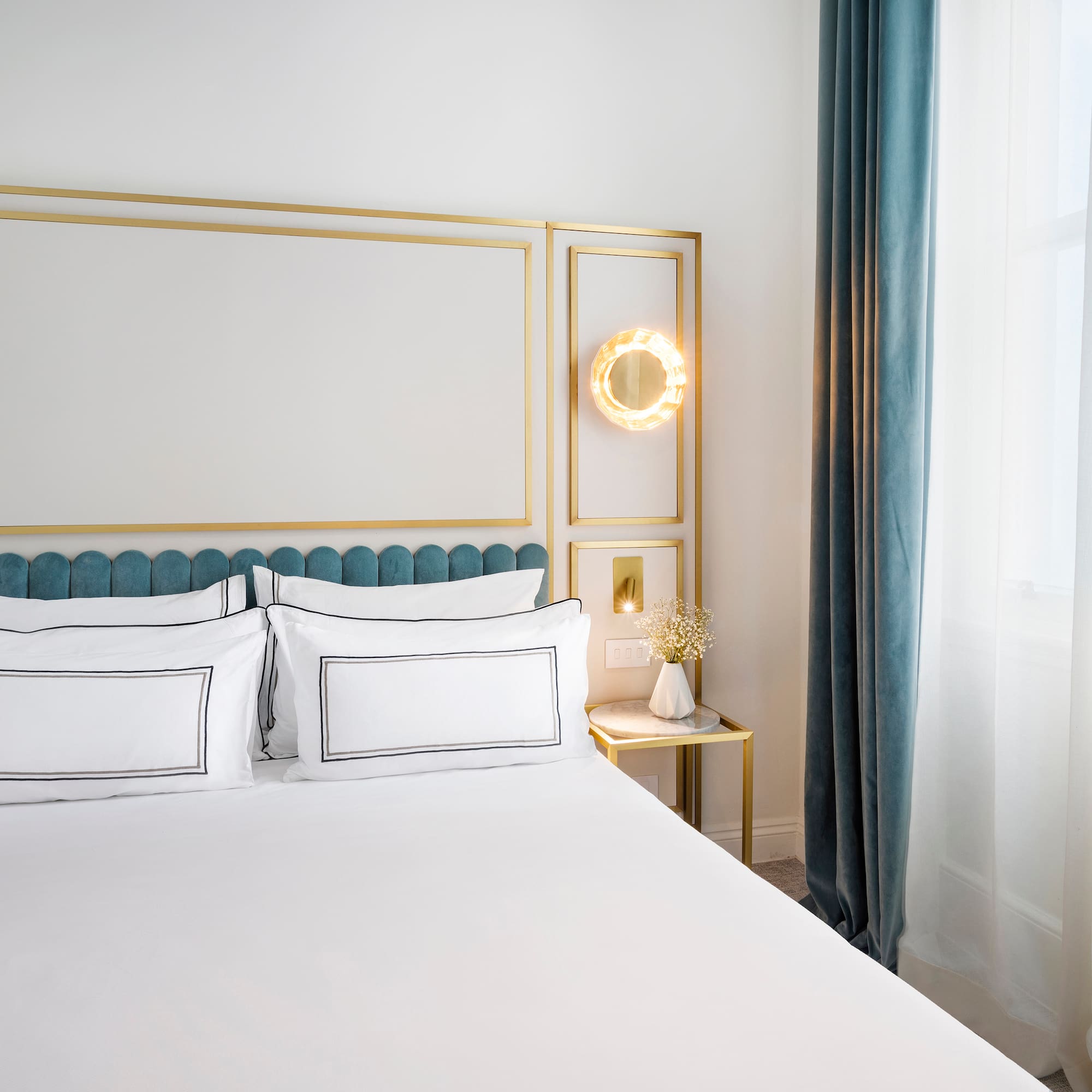 a bed with white sheets and a gold frame