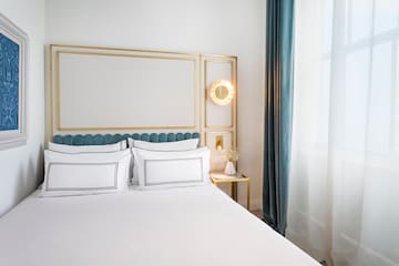 a bed with white sheets and a gold frame