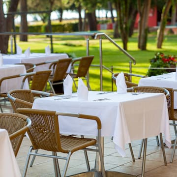 tables and chairs outside with white tablecloths and napkins