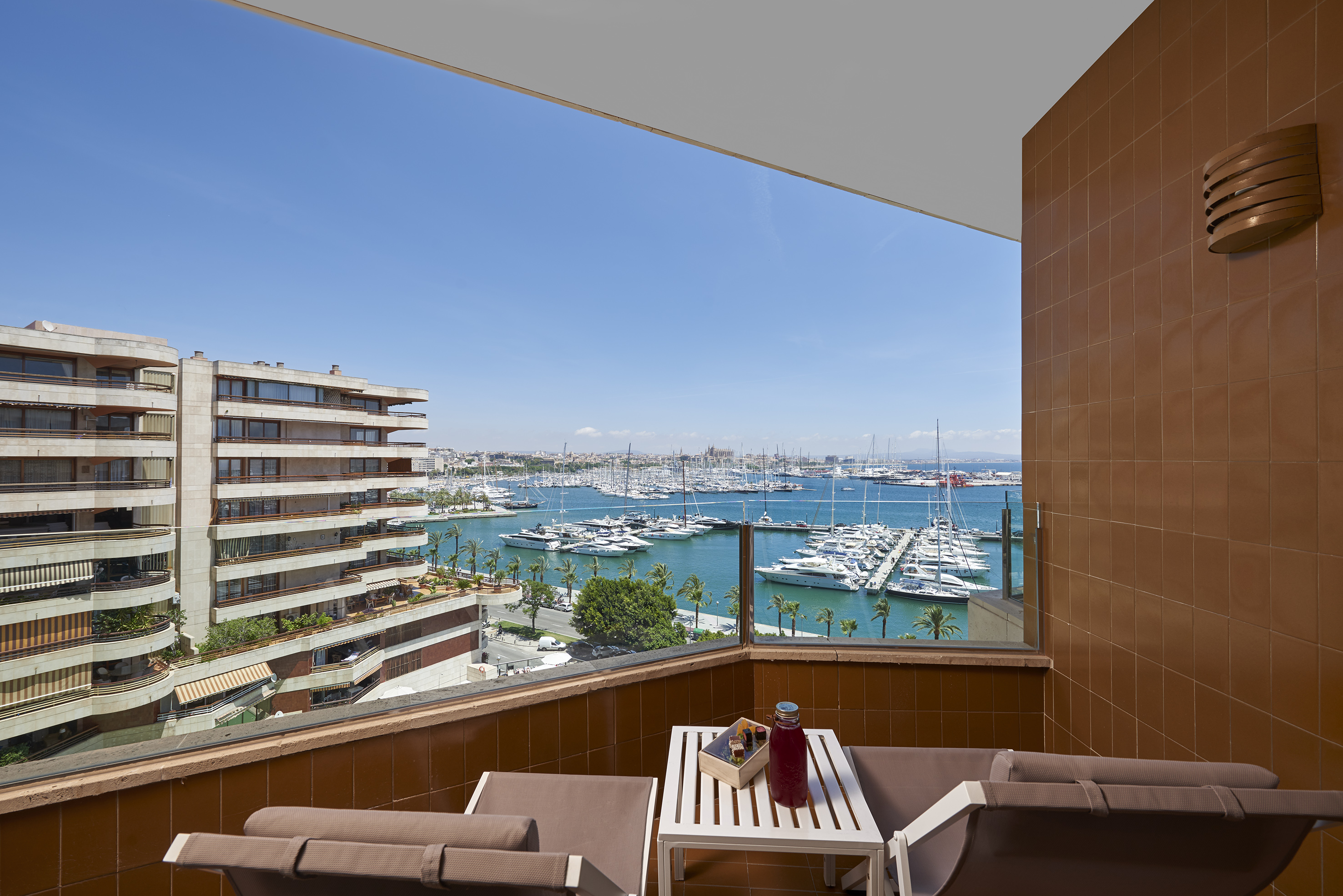 Balcony with lounge chairs, marina view, and numerous yachts.