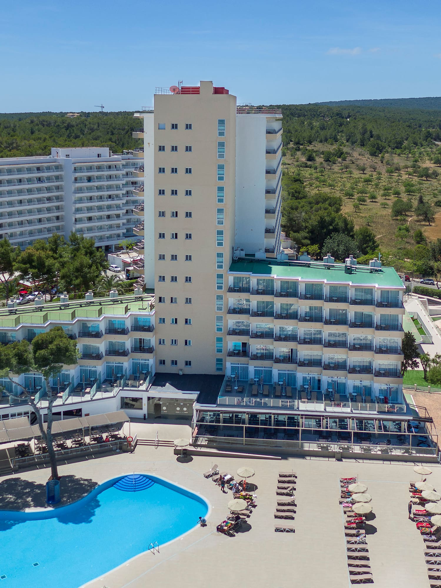 a large building with a pool and trees in the background