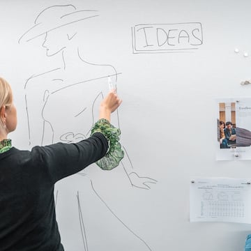 a woman drawing on a white board