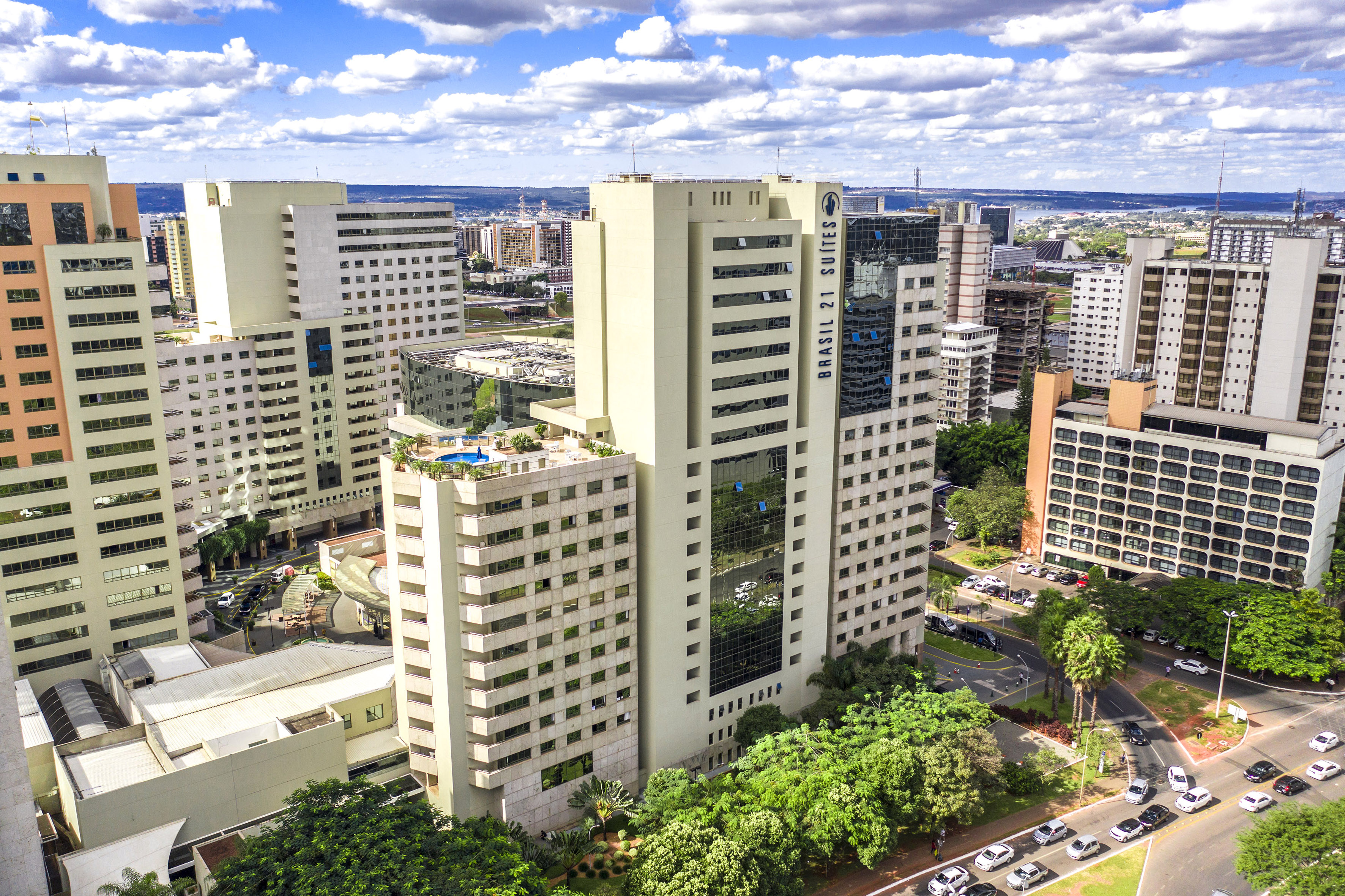 Brasilia cityscape aerial: Brasil 21 Suites hotel, modern buildings, rooftop pool.