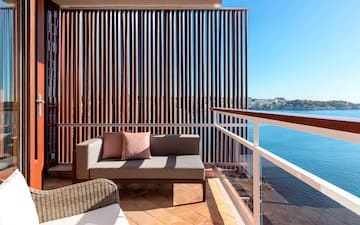 a couch on a balcony overlooking water