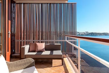 a couch on a balcony overlooking water