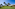 Tropical resort: white bungalows, palm trees, and sunny green lawn.