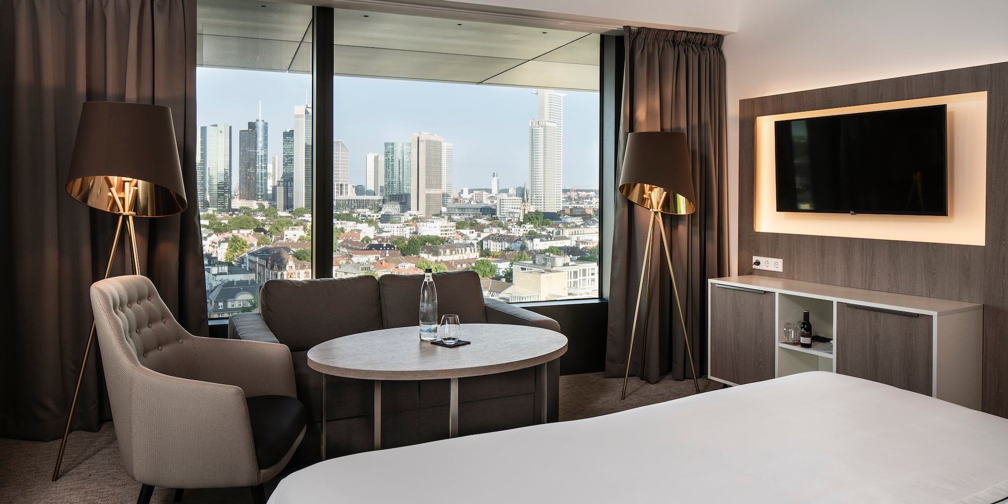 a room with a bed and a table and a television