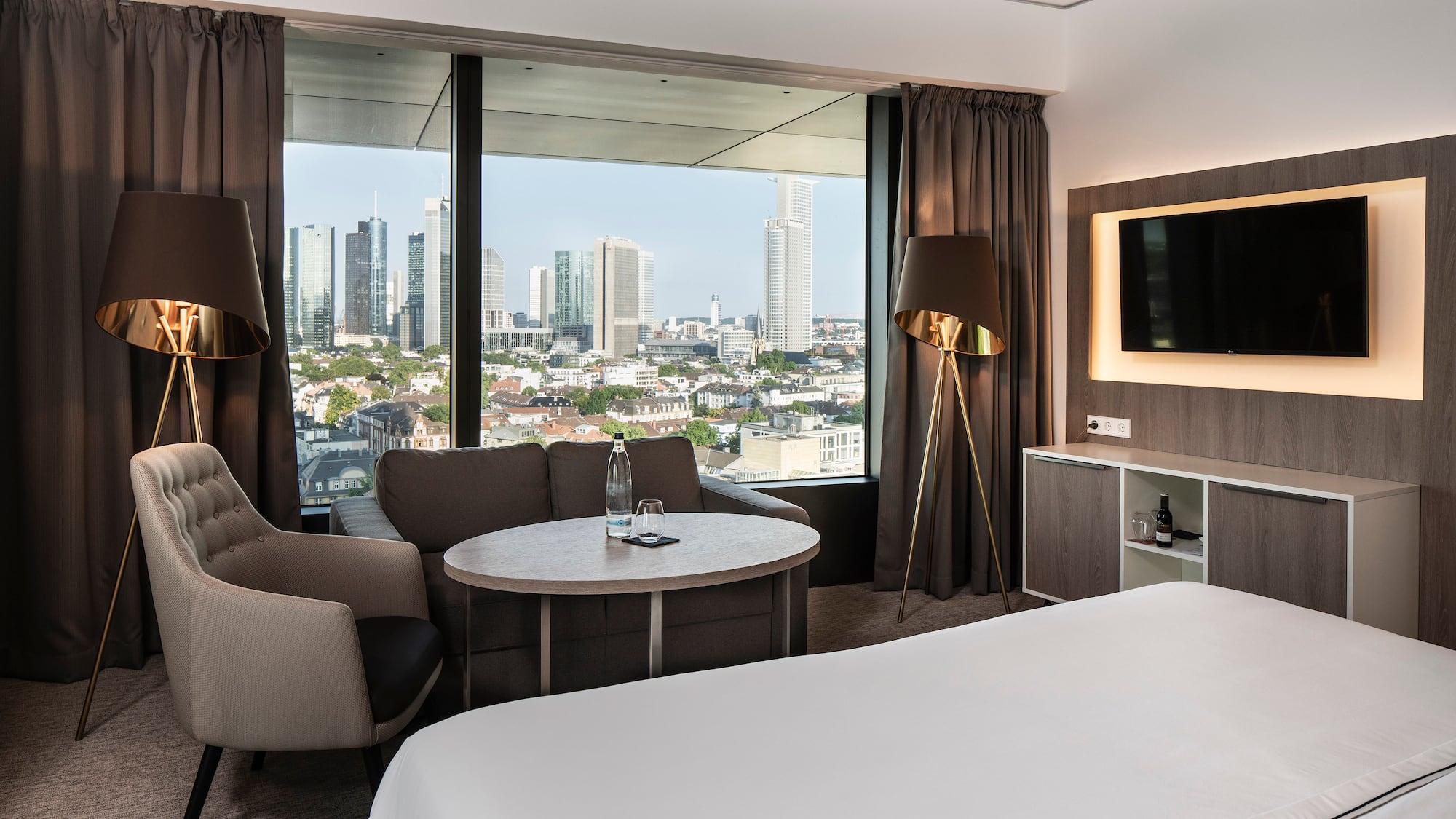 a room with a bed and a table and a television