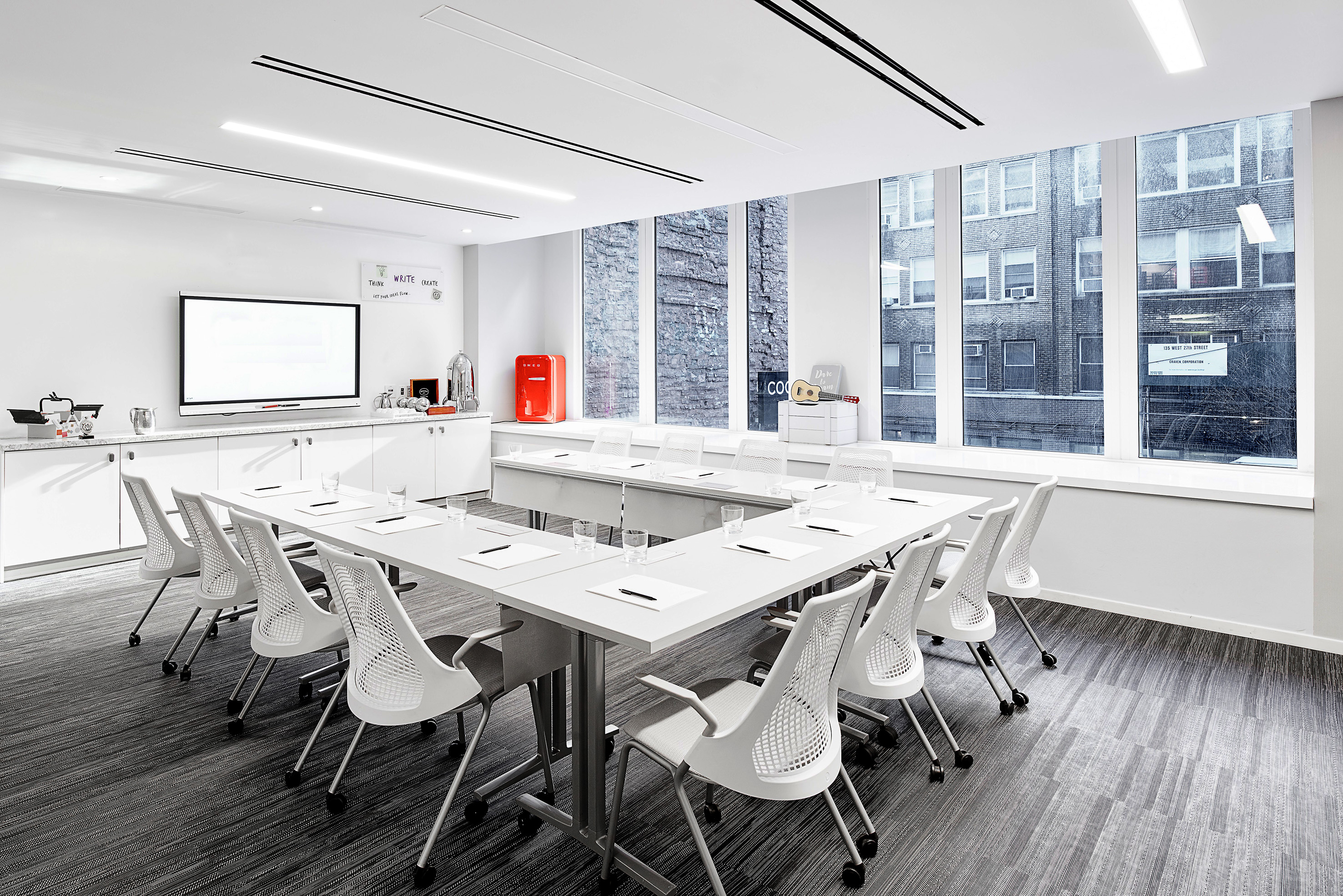 Modern office conference room: U-shaped table, white chairs, TV, city view. - NoMad - INNSiDE New York NoMad, Nueva York