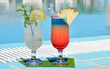 two glasses with drinks on a table