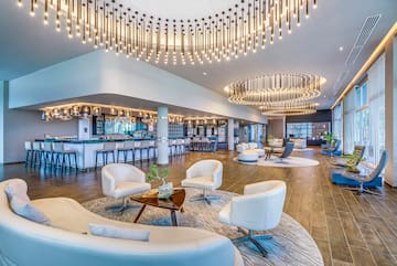 a large room with white chairs and a bar