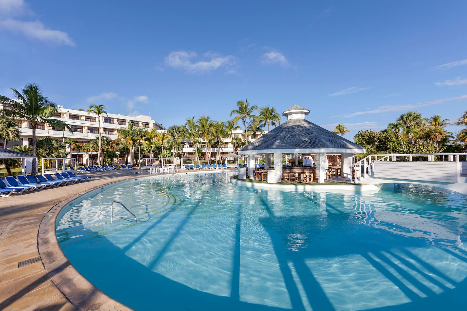 a pool with a gazebo and palm trees