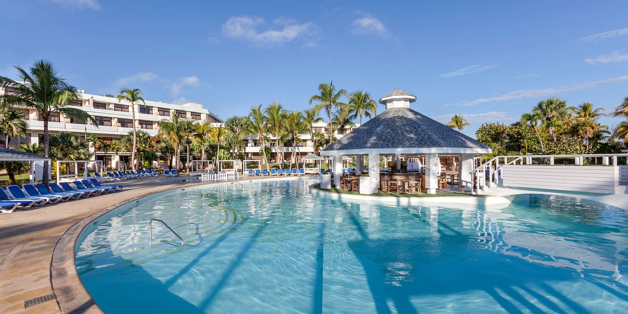 a pool with a gazebo and palm trees