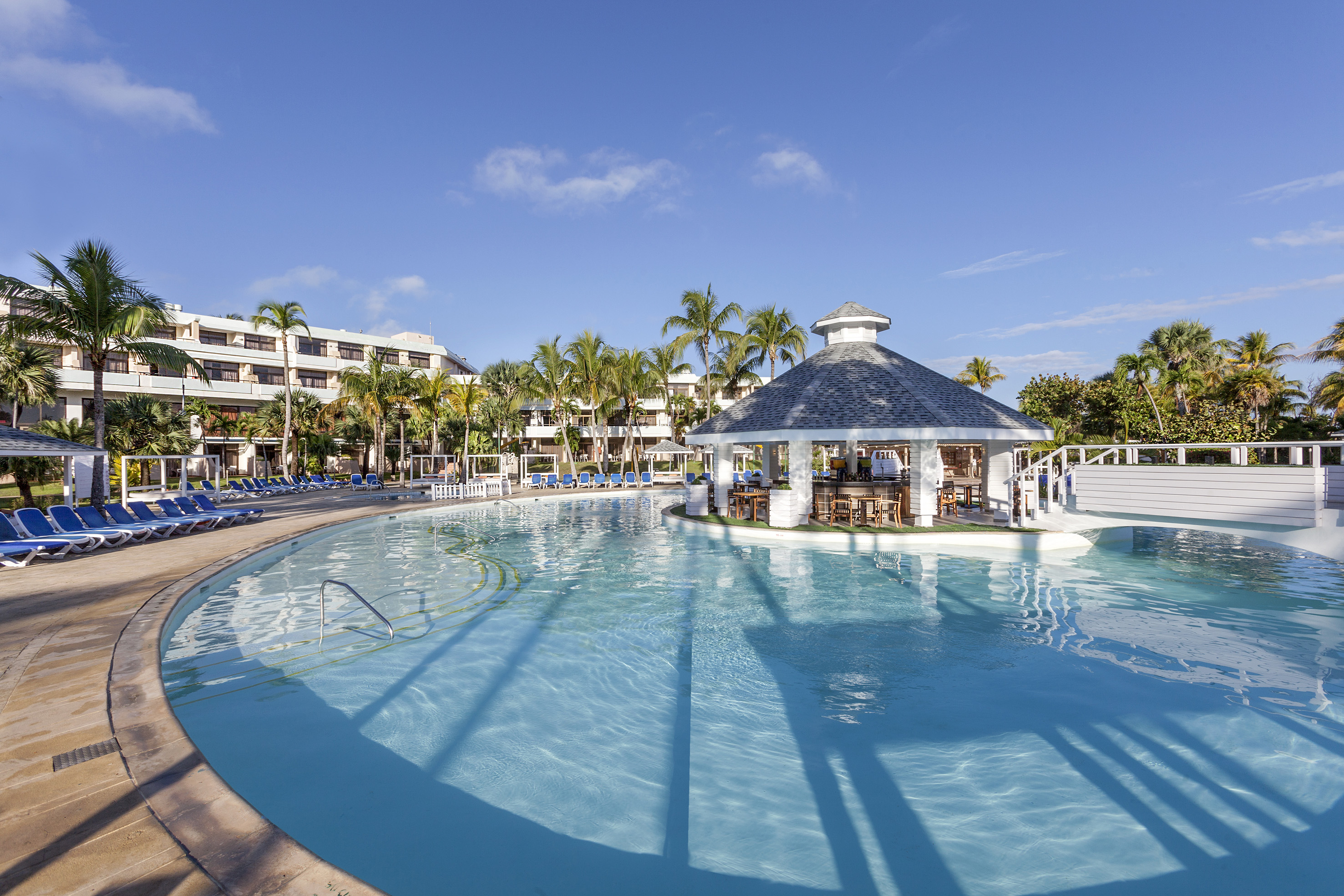 a pool with a gazebo and palm trees