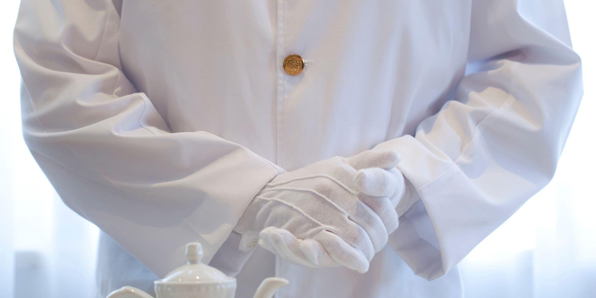 a person in a white coat and gloves