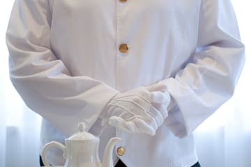 a person in a white coat and gloves