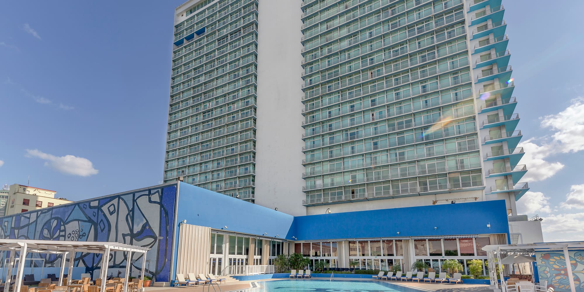a large building with a pool and chairs