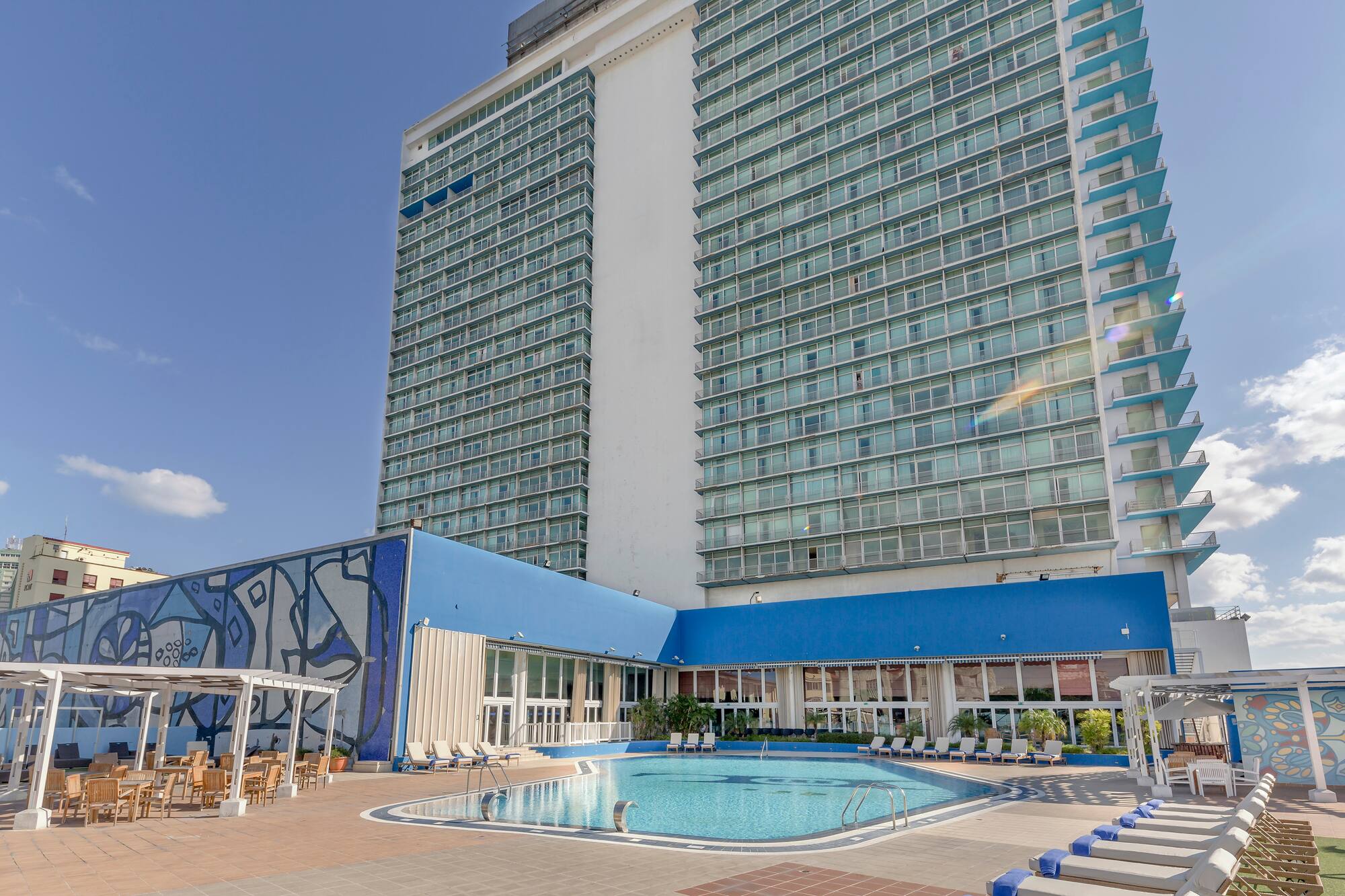 a large building with a pool and chairs