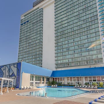 a large building with a pool and chairs