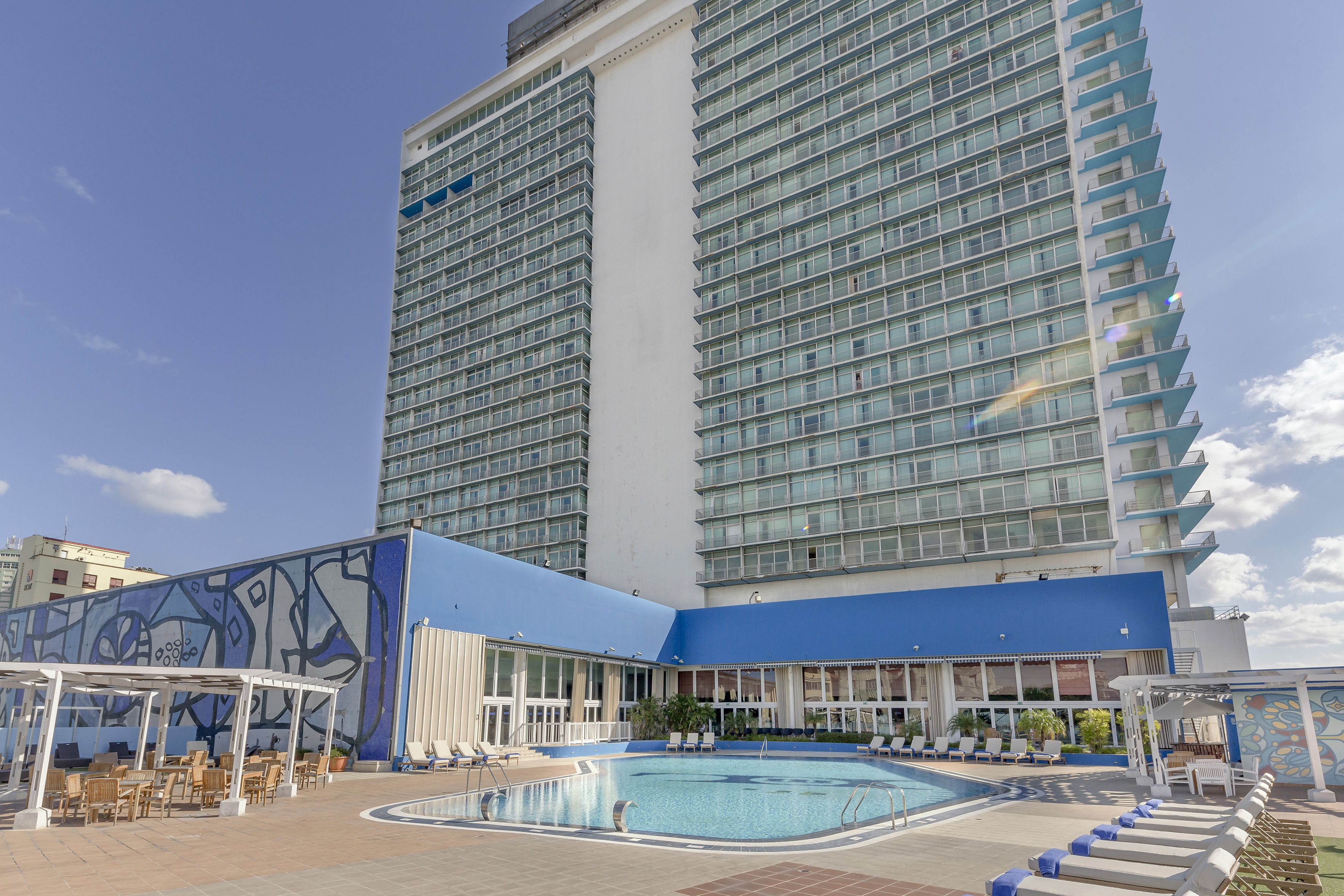 a large building with a pool and chairs
