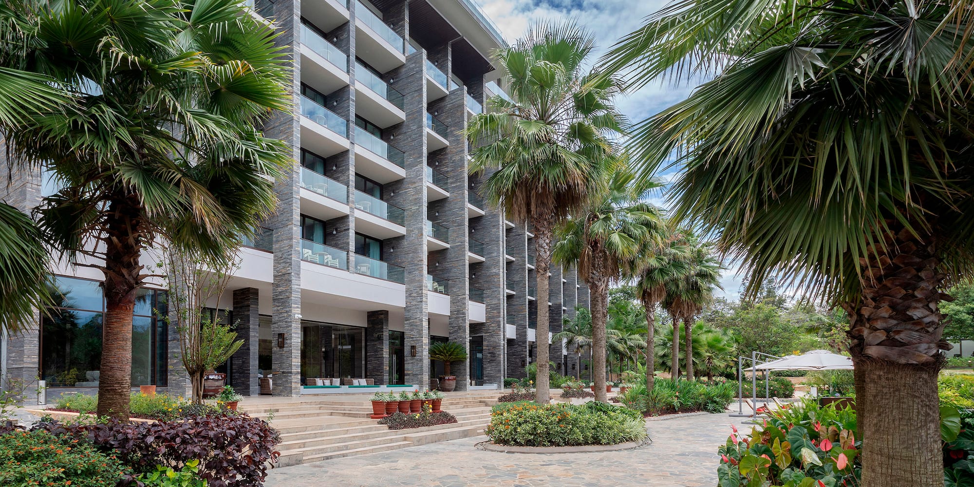 a building with palm trees and plants