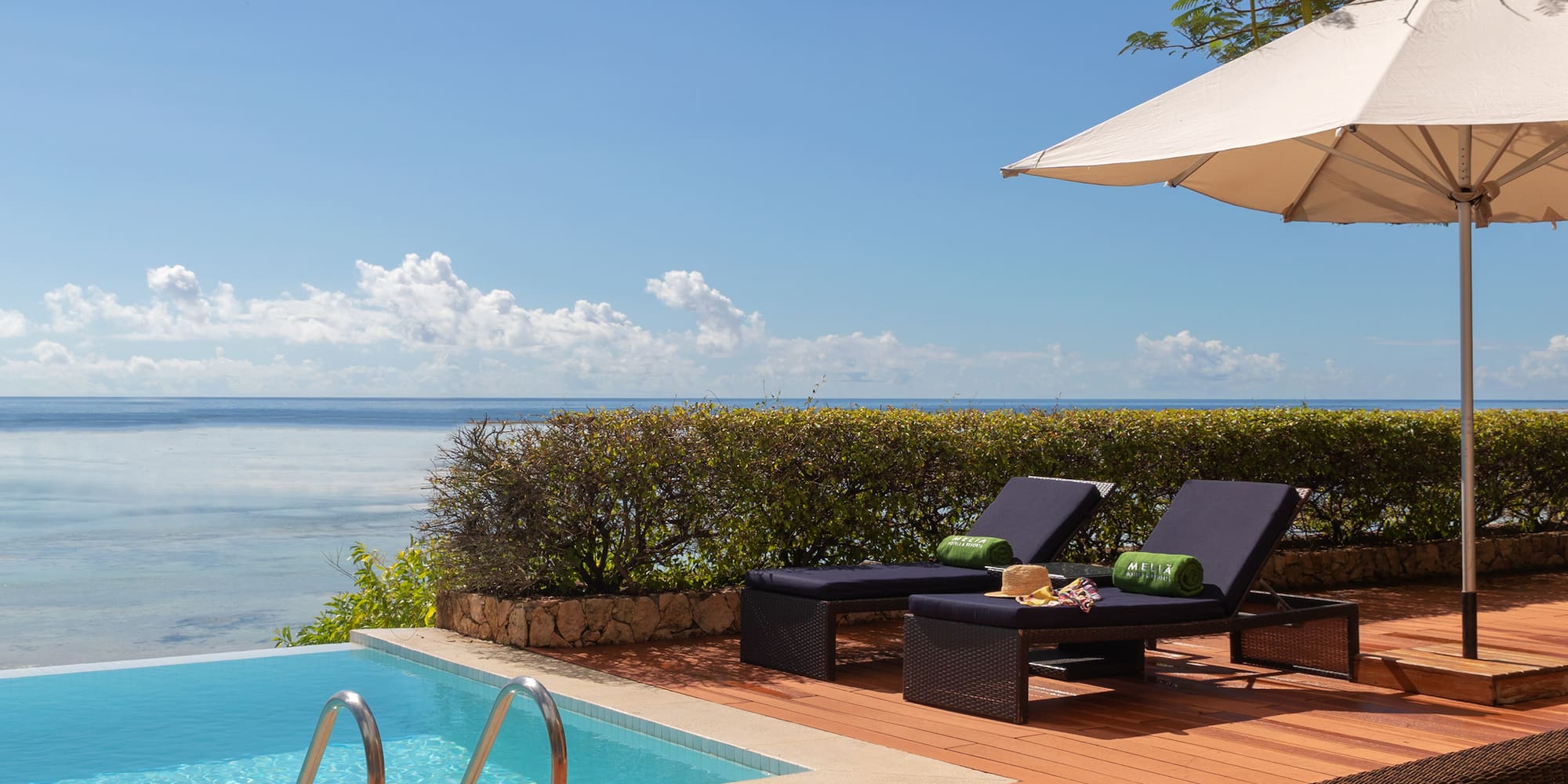 a pool with chairs and umbrella by it