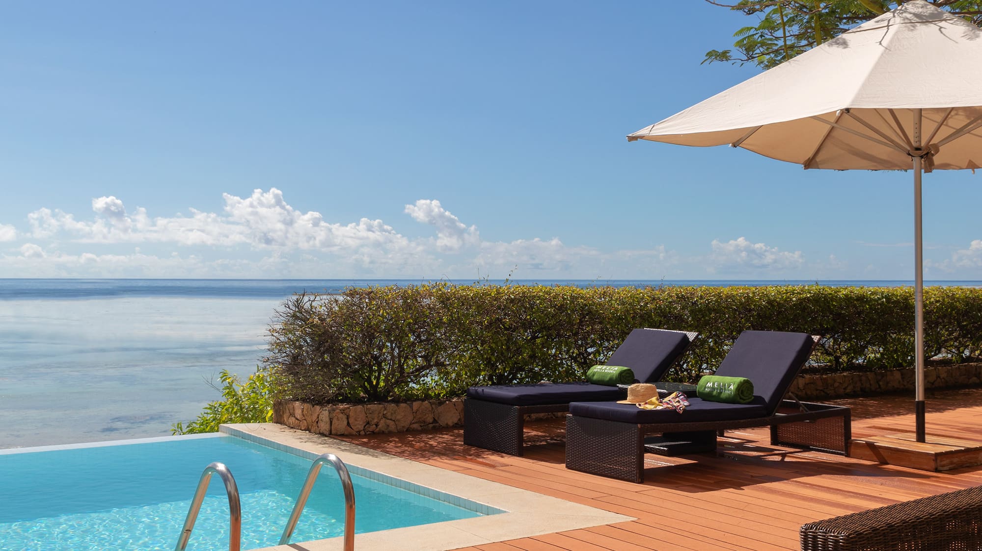 a pool with chairs and umbrella by it