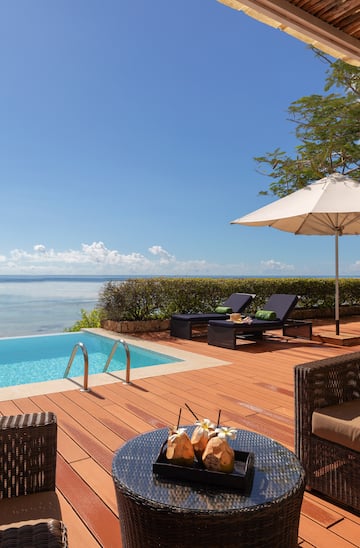 a pool with chairs and umbrella by it