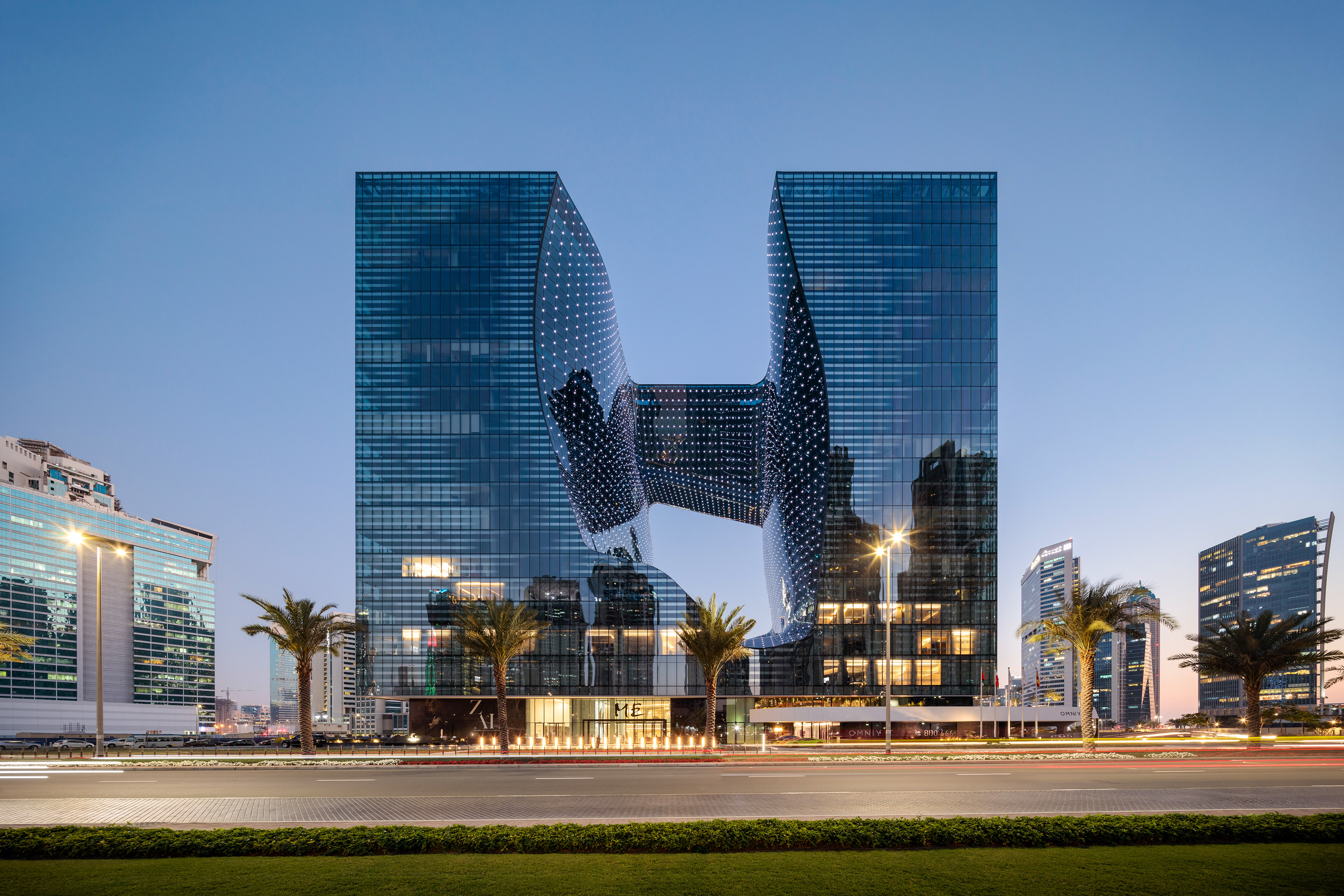 Zaha Hadid's The Opus building in Dubai at dusk, modern glass architecture.