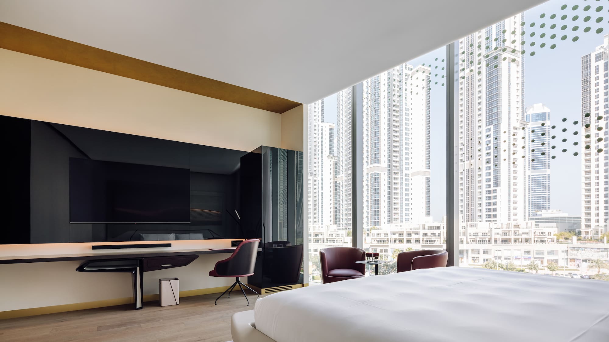 a room with a large bed and a desk and chairs