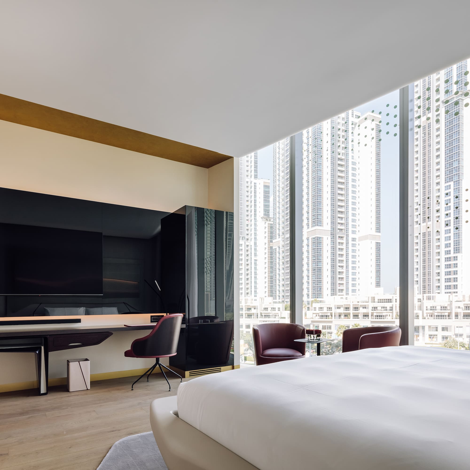 a room with a large bed and a desk and chairs