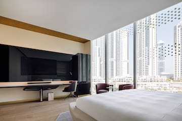 a room with a large bed and a desk and chairs