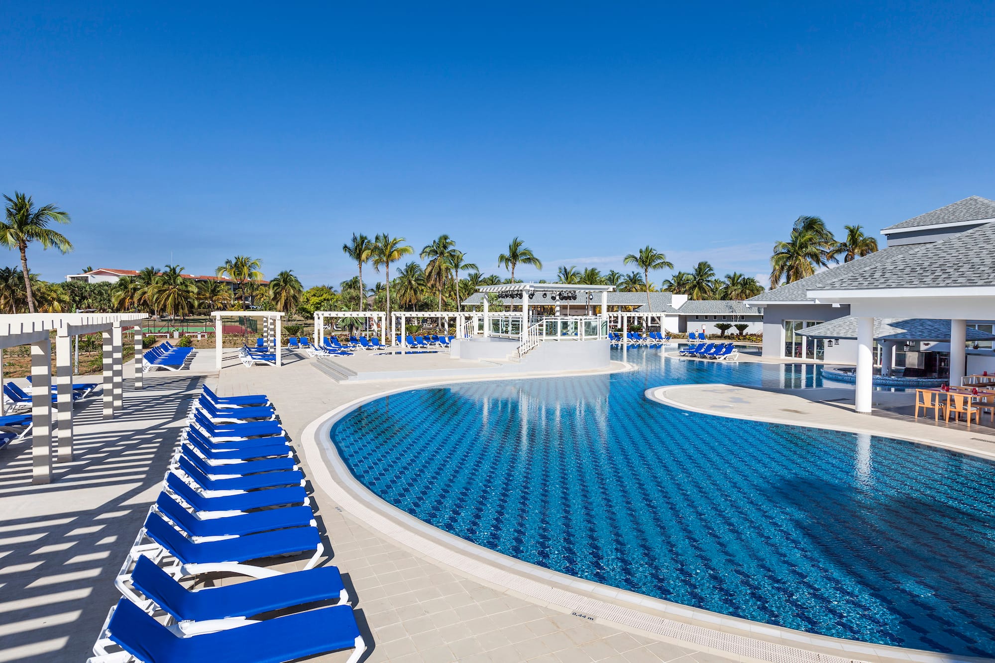 a pool with lounge chairs and a gazebo