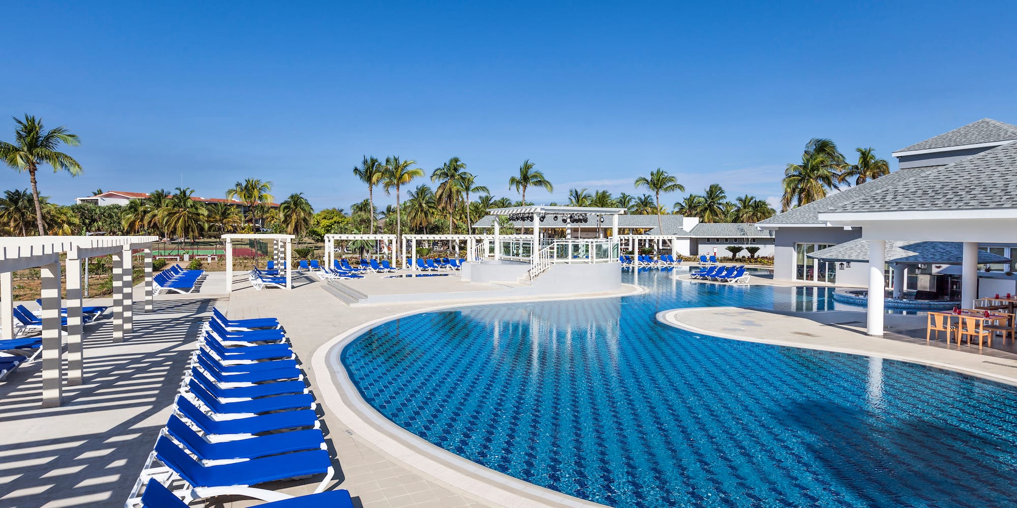 a pool with lounge chairs and a gazebo
