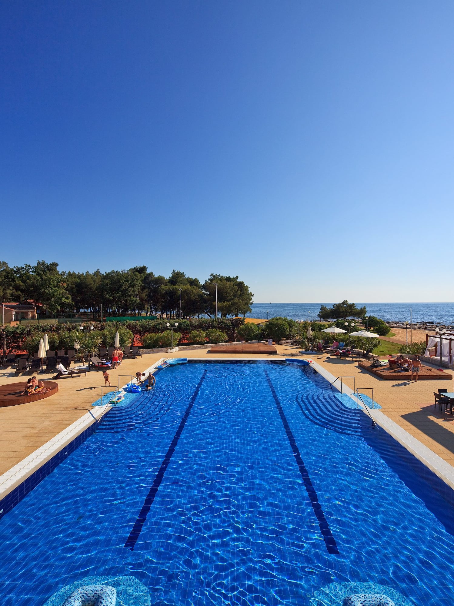 a swimming pool with people on the beach
