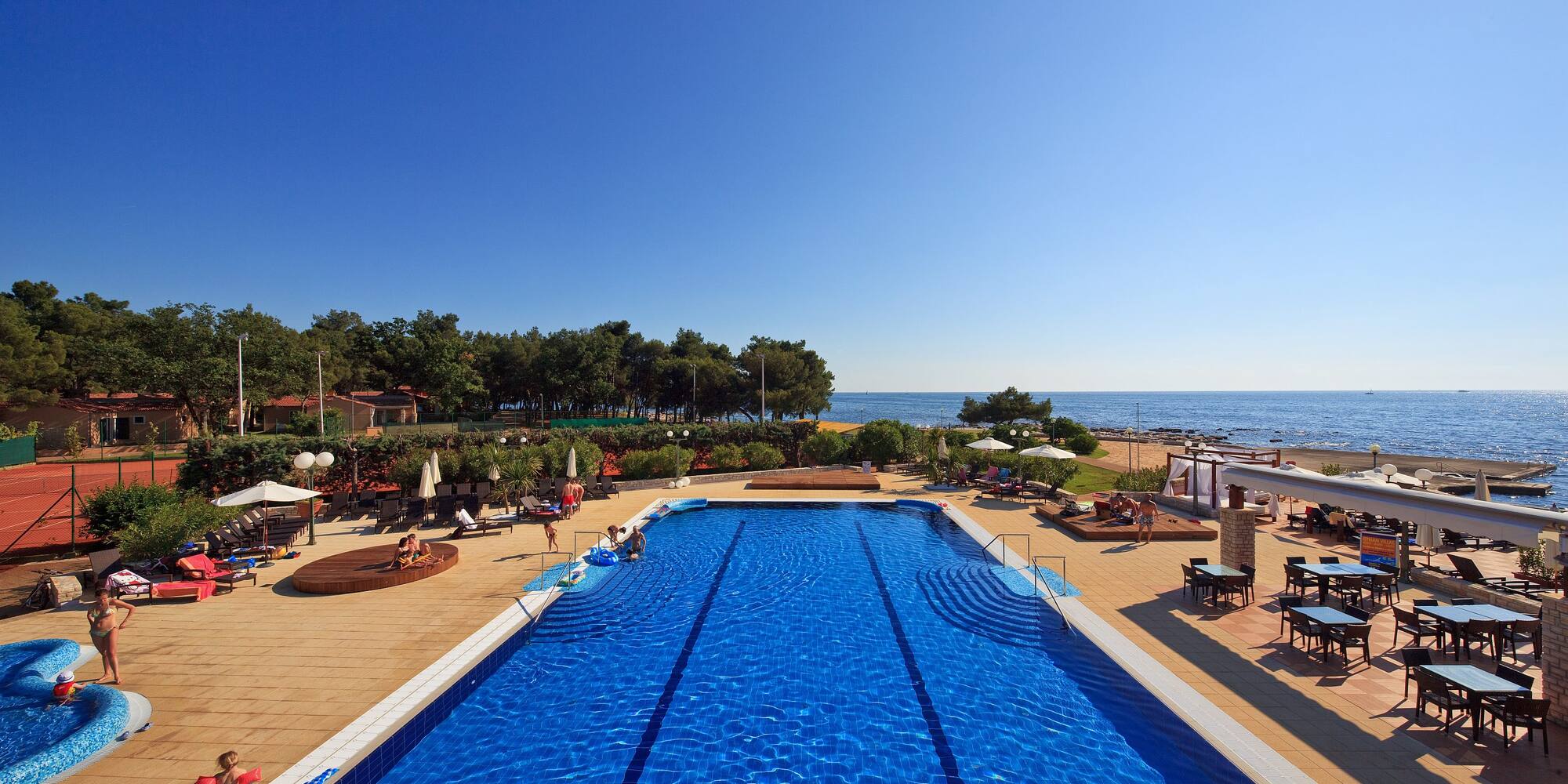 a swimming pool with people on the beach