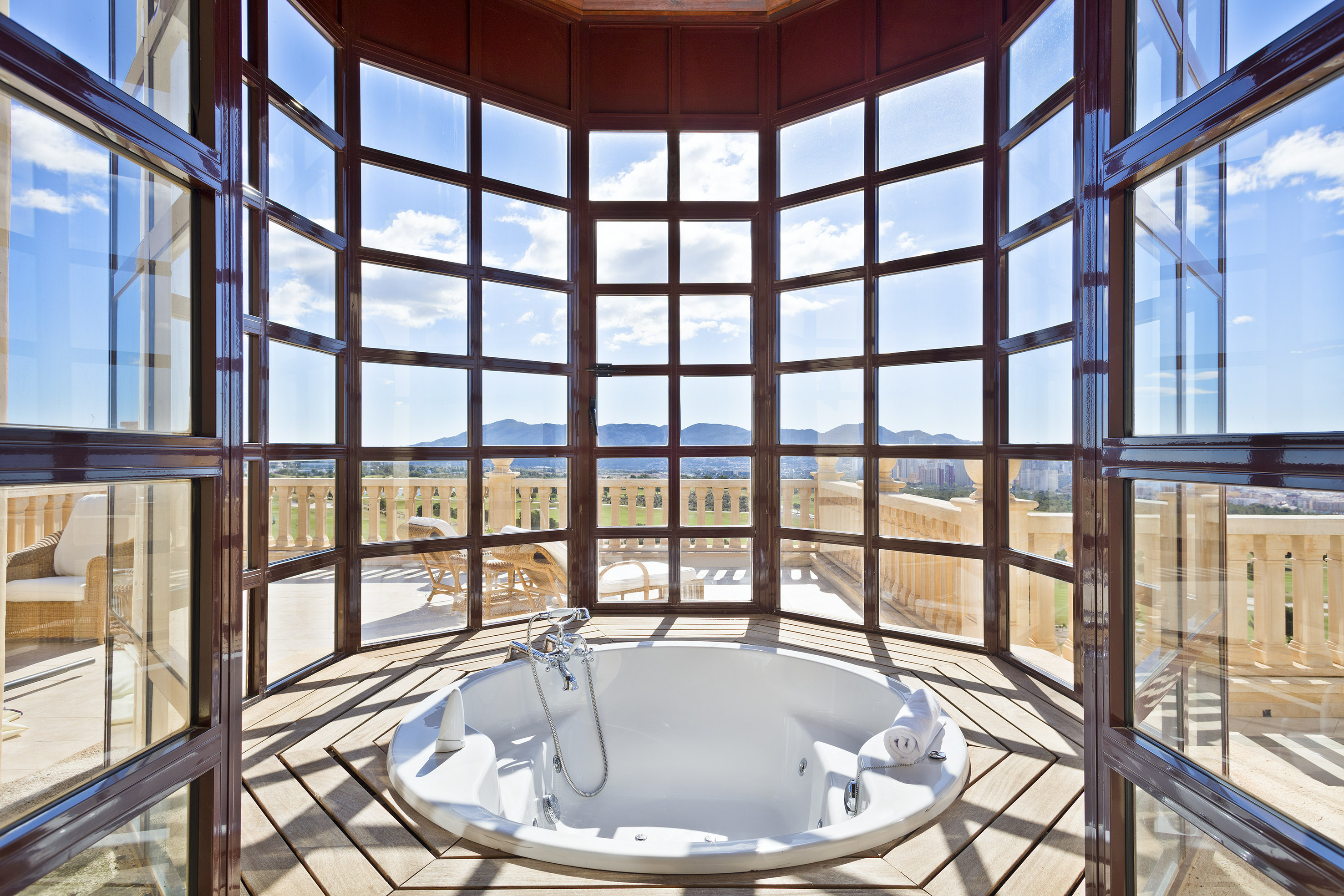 Luxury jacuzzi with panoramic mountain views from expansive windows.
